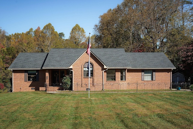 view of front of home with a shingled roof, a front lawn, and brick siding