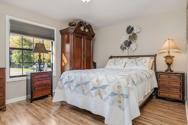 bedroom featuring light wood-style floors, baseboards, and multiple windows