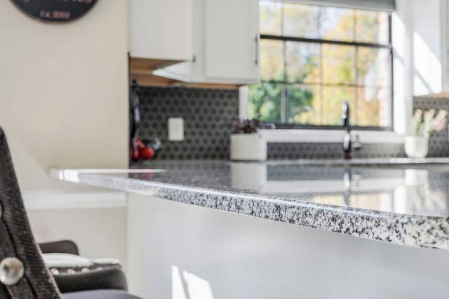 kitchen featuring backsplash and white cabinetry