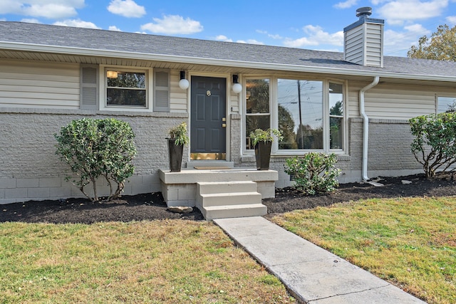 entrance to property with a lawn