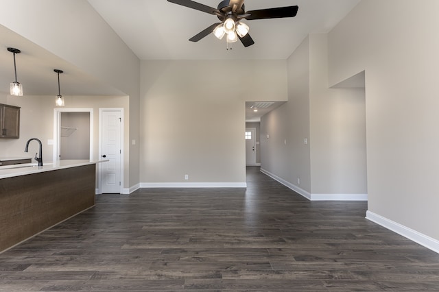 unfurnished living room with visible vents, dark wood-type flooring, a ceiling fan, a sink, and baseboards