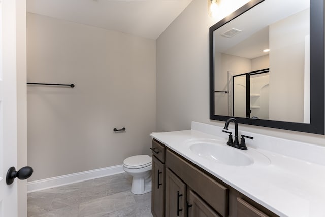 bathroom featuring vanity, toilet, and a shower with door