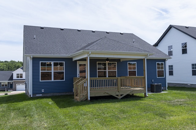 rear view of property with a ceiling fan, cooling unit, a lawn, and a shingled roof