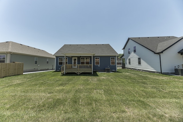 rear view of house with cooling unit, a yard, a deck, and fence