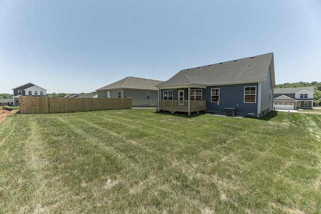 rear view of property with a lawn, a deck, and central air condition unit