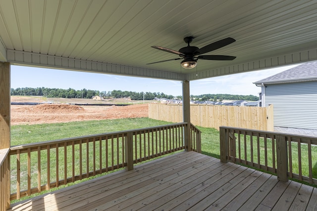 wooden deck featuring a rural view, ceiling fan, and a lawn