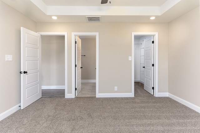 unfurnished bedroom with visible vents, a walk in closet, recessed lighting, carpet floors, and baseboards