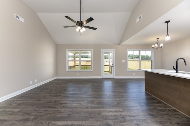 unfurnished living room featuring dark wood finished floors, visible vents, ceiling fan with notable chandelier, and baseboards