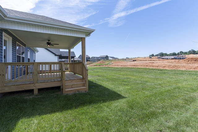 view of yard with a deck and a ceiling fan