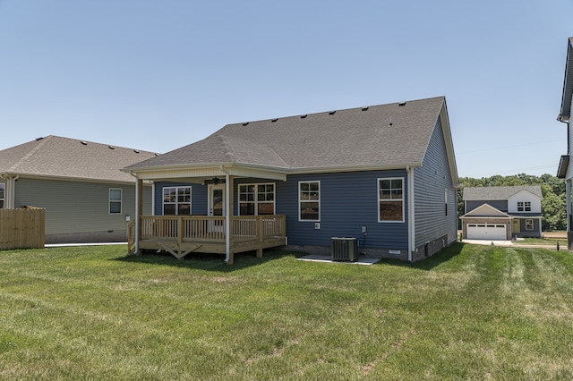 rear view of house with central AC unit, a deck, and a lawn