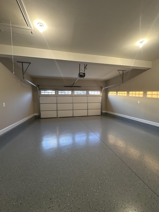 garage featuring a garage door opener and baseboards