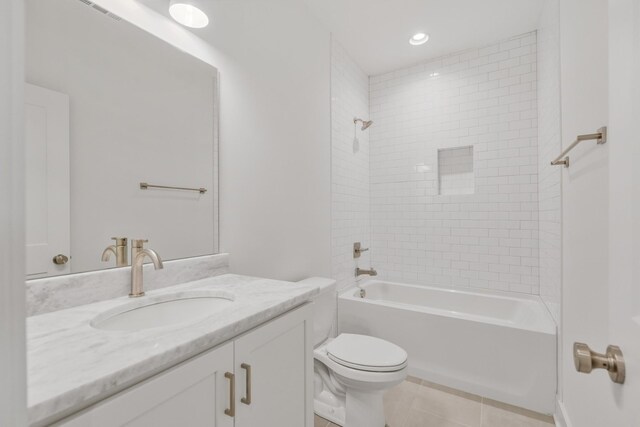 full bathroom featuring toilet, tile patterned floors, vanity, and tiled shower / bath