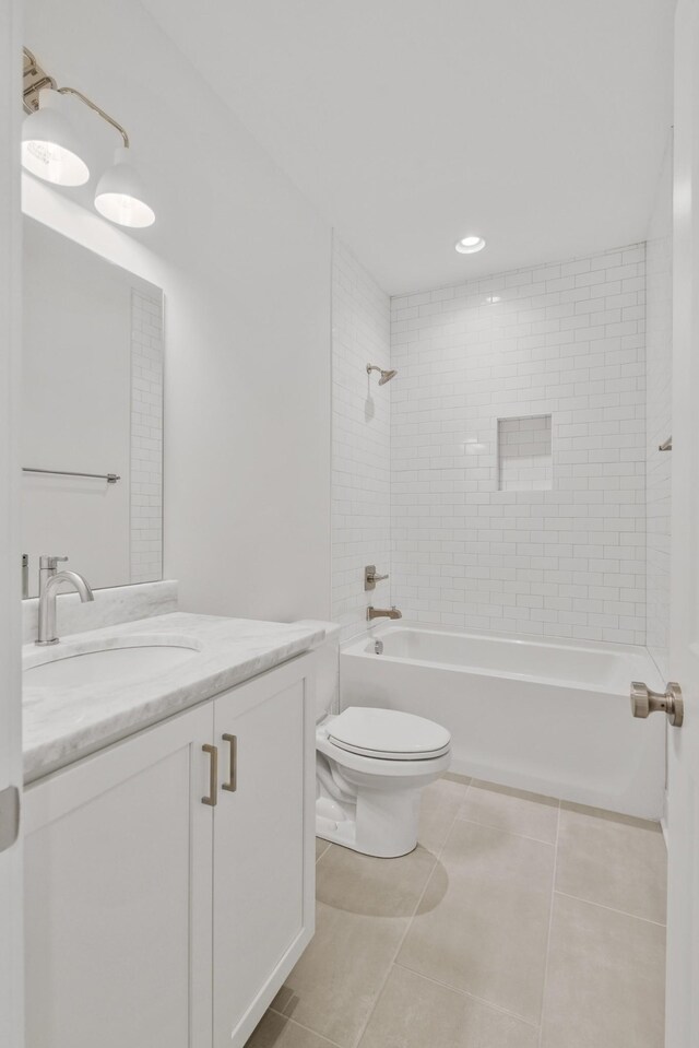 full bathroom featuring vanity, toilet, tiled shower / bath combo, and tile patterned flooring