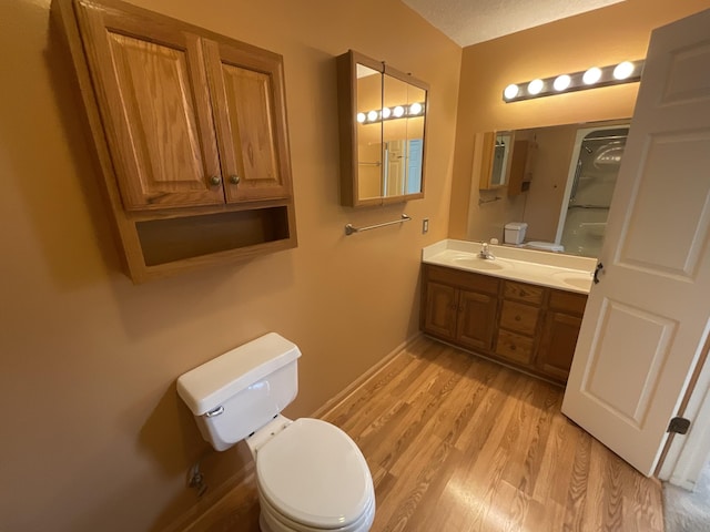 bathroom with hardwood / wood-style flooring, vanity, toilet, and a textured ceiling