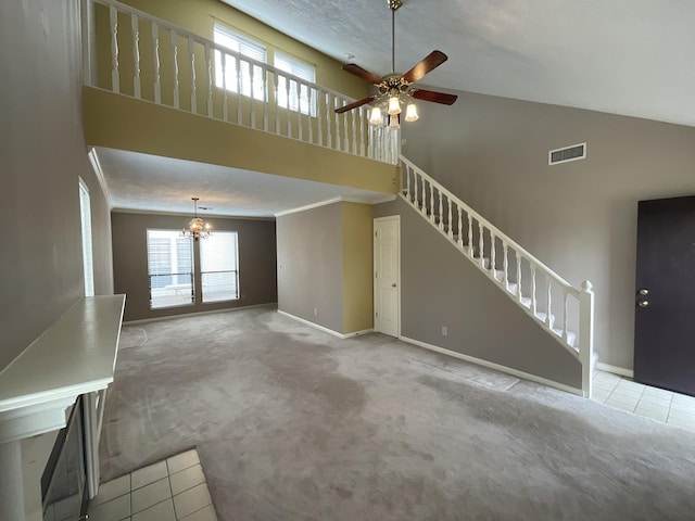 unfurnished living room featuring a high ceiling, a healthy amount of sunlight, and light colored carpet