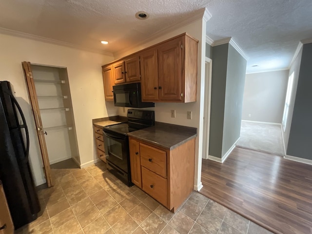 kitchen with crown molding, a textured ceiling, and black appliances