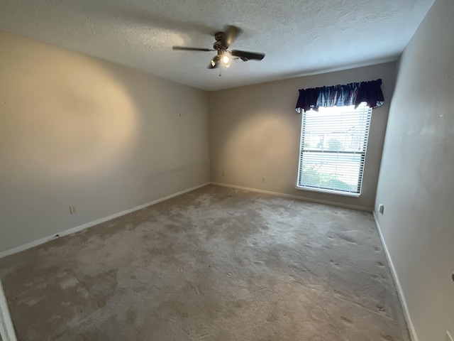 carpeted spare room with ceiling fan and a textured ceiling