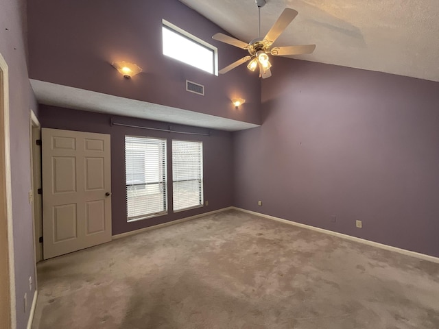 empty room featuring ceiling fan, light colored carpet, and lofted ceiling