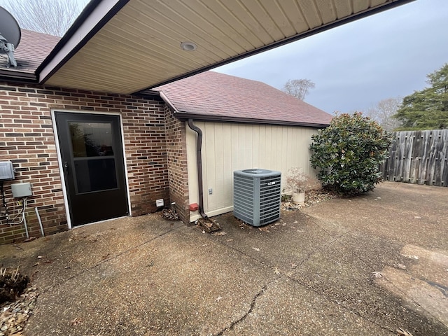 view of exterior entry featuring a patio and central air condition unit