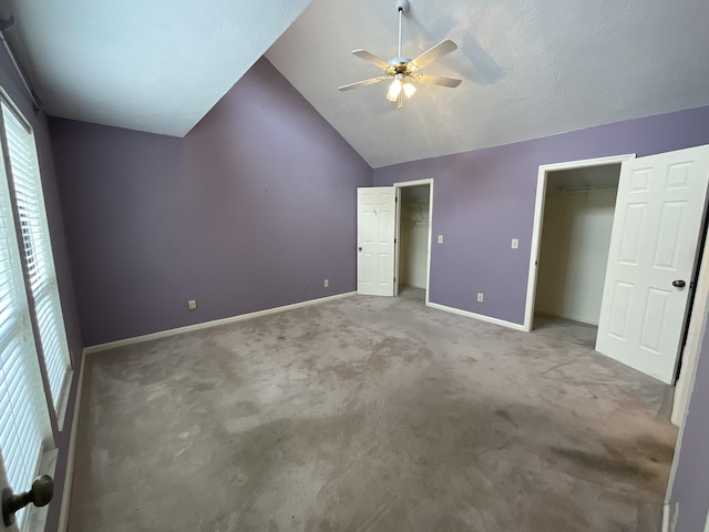 unfurnished bedroom featuring ceiling fan, carpet flooring, and vaulted ceiling