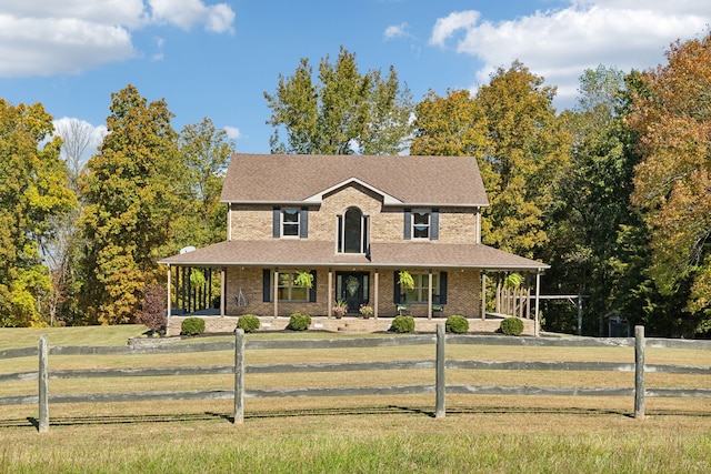 farmhouse with covered porch and a front lawn