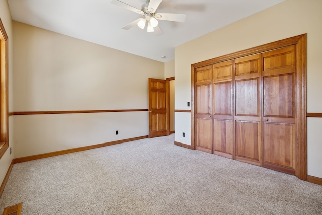 unfurnished bedroom featuring light carpet, a closet, and ceiling fan