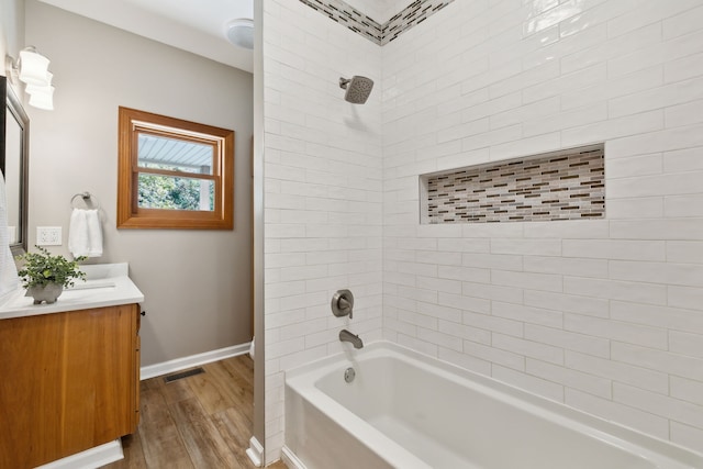 bathroom featuring vanity, hardwood / wood-style floors, and tiled shower / bath combo