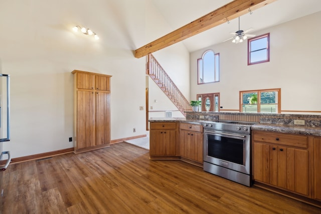 kitchen with stainless steel electric stove, high vaulted ceiling, beamed ceiling, and dark hardwood / wood-style flooring