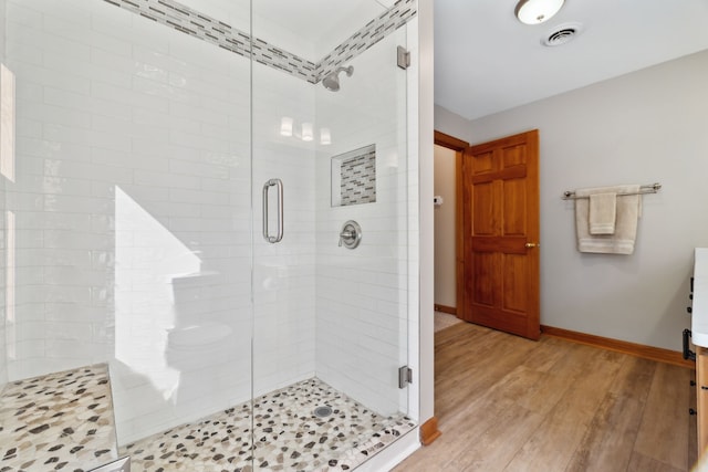 bathroom with a shower with door, vanity, and hardwood / wood-style flooring