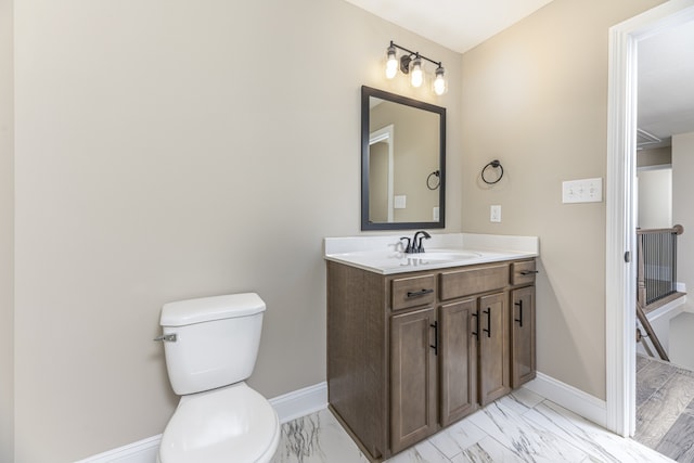 bathroom featuring marble finish floor, toilet, vanity, and baseboards