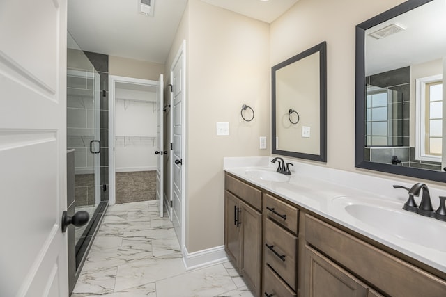 bathroom featuring a sink, visible vents, marble finish floor, and a stall shower