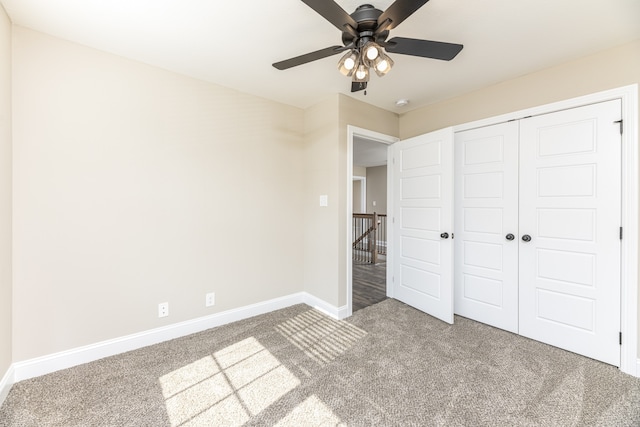 unfurnished bedroom with ceiling fan, carpet flooring, and a closet