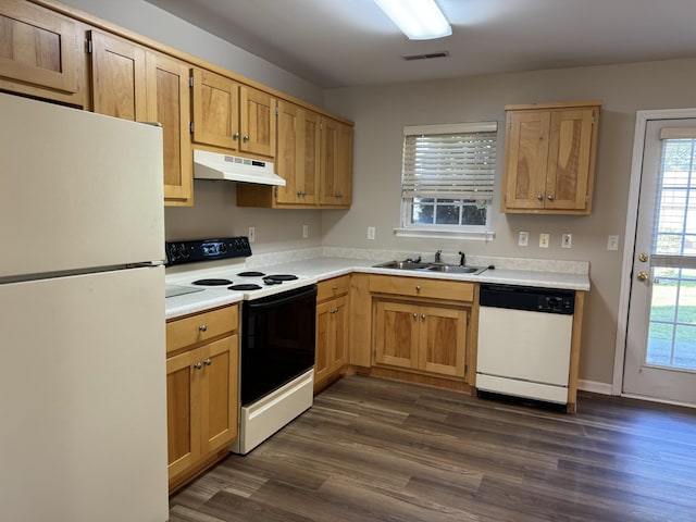 kitchen featuring a sink, light countertops, under cabinet range hood, dark wood-type flooring, and white appliances