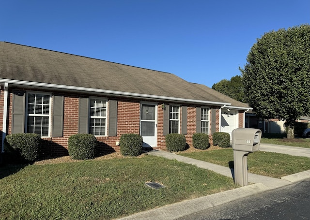 view of front of home with brick siding, a front yard, concrete driveway, and an attached garage
