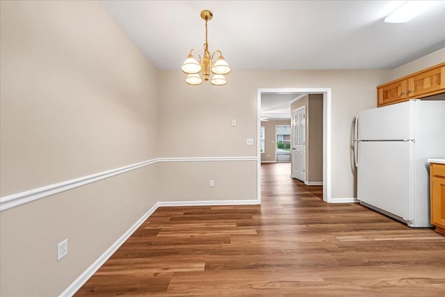 105 Middleton Ct, Tullahoma, TN 37388 - kitchen with hanging light fixtures, wood finished floors, baseboards, freestanding refrigerator, and an inviting chandelier