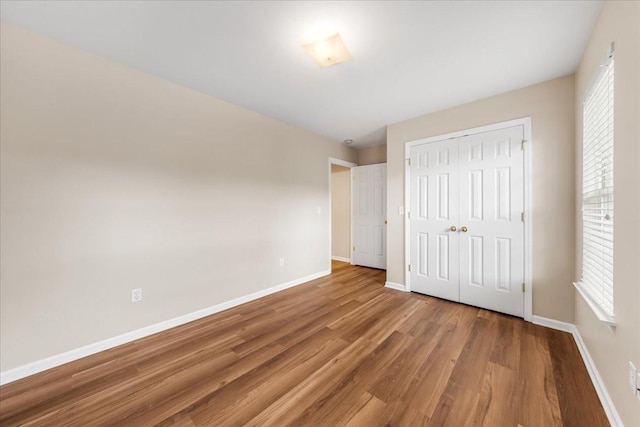 105 Middleton Ct, Tullahoma, TN 37388 - unfurnished bedroom featuring baseboards, multiple windows, wood finished floors, and a closet
