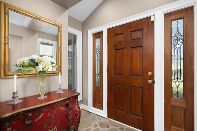 foyer with crown molding and lofted ceiling