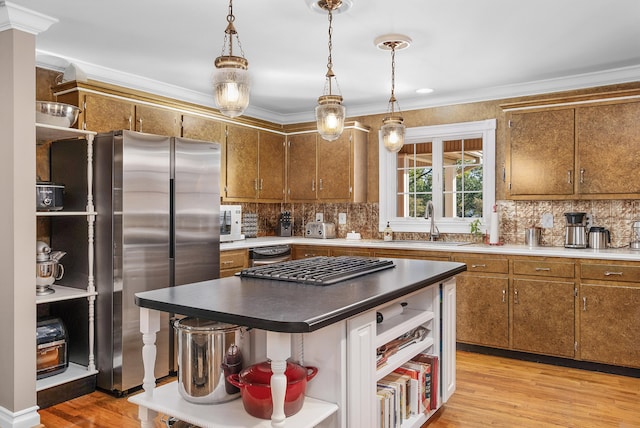 kitchen with sink, a center island, stainless steel fridge, crown molding, and light hardwood / wood-style flooring