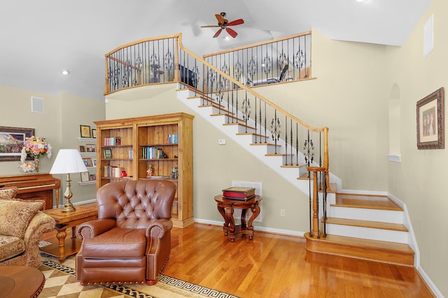 living room with hardwood / wood-style flooring, high vaulted ceiling, and ceiling fan