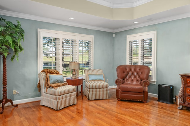 sitting room with ornamental molding and light hardwood / wood-style floors