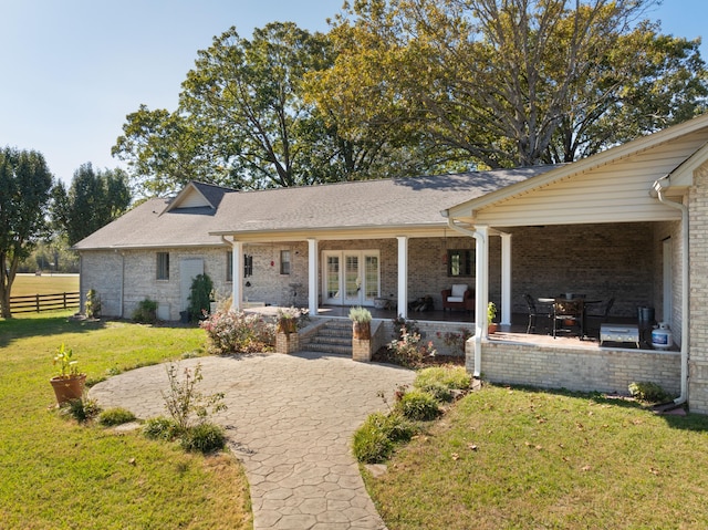 ranch-style house with french doors, a patio, and a front yard