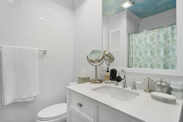 bathroom with toilet, ornamental molding, vanity, and tile walls