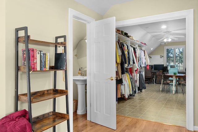 walk in closet with sink, ceiling fan, vaulted ceiling, and hardwood / wood-style floors