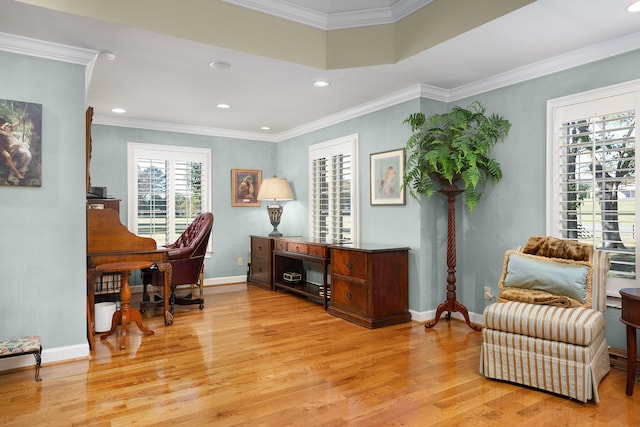 living area featuring crown molding and light wood-type flooring