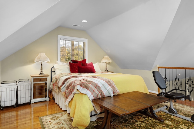 bedroom with vaulted ceiling and light hardwood / wood-style flooring