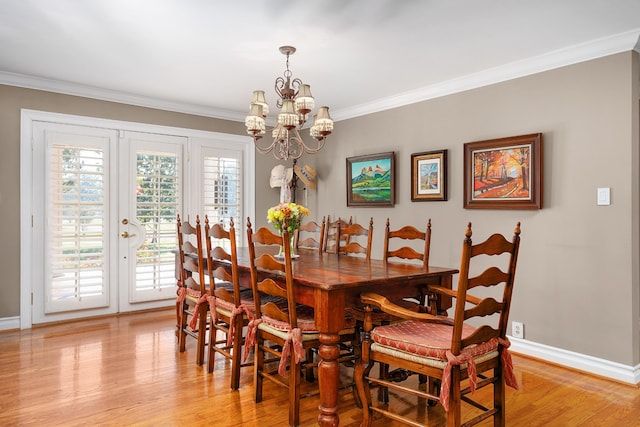 dining space with ornamental molding, a chandelier, and light wood-type flooring