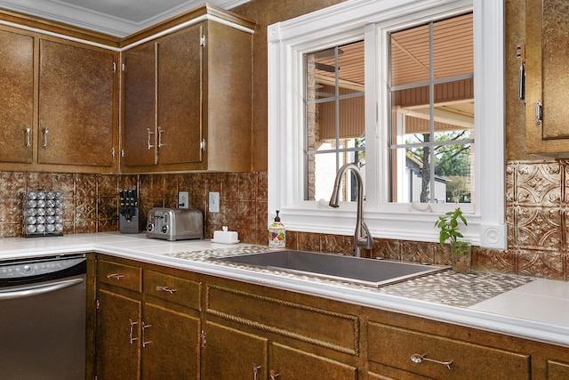 kitchen with crown molding, decorative backsplash, sink, and stainless steel dishwasher