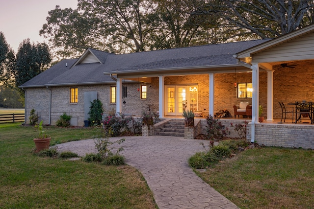 view of front of house featuring a patio area, french doors, and a lawn