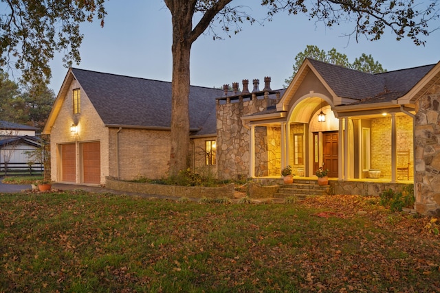 view of front of property featuring a garage and a lawn