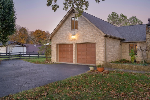 view of garage at dusk